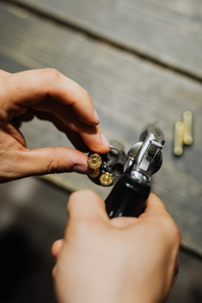 zipwp-image-5202390 Hands of a Person Holding Silver and Black Gun With Bullets
